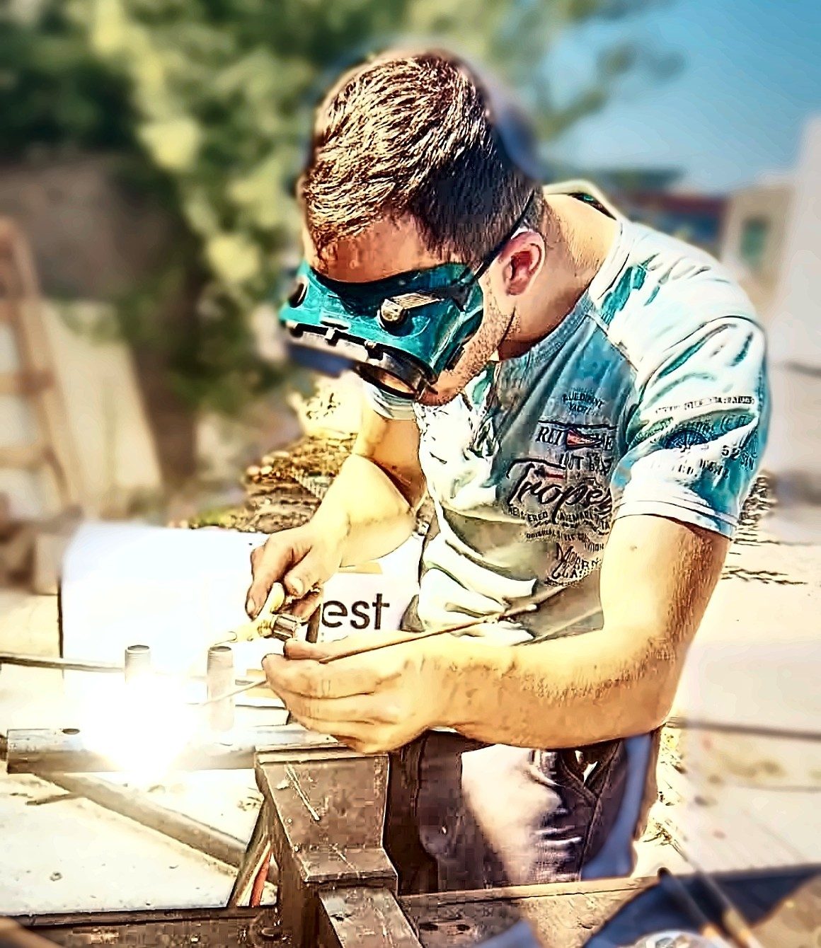 Installateur OMJ ÉNERGIE en train de braser un collecteur au chalumeau, lunettes de protection